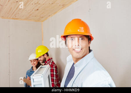 Esperto artigiano sorridente e la creazione di una nuova finestra Foto Stock