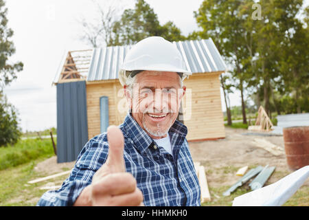 Senior come maestro artigiano tenendo pollice in alto Foto Stock