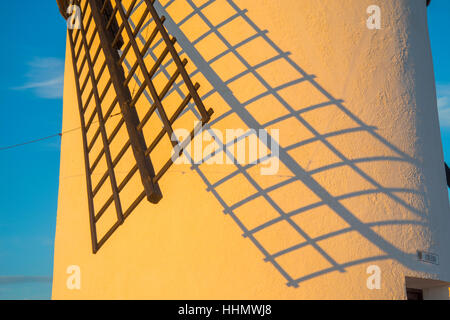 Braccio di mulino a vento e la sua ombra sul muro al tramonto. Campo de Criptana, Ciudad Real Provincia, Castilla La Mancha, in Spagna. Foto Stock