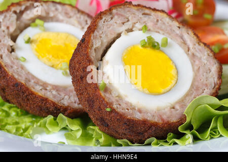Una sana prima colazione a base di carne uova ripiene sulla lattuga. orizzontale macro Foto Stock