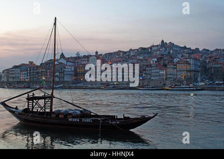 Portogallo: barche al tramonto e lo skyline del Porto con vista del fiume Douro tra le città di Porto e di Vila Nova de Gaia