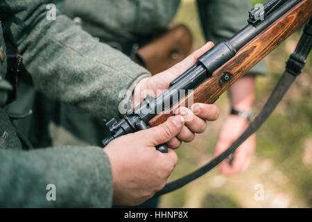 Unidentified ri-enactor vestito come soldato tedesco della II Guerra Mondiale azienda tenendo un fucile. Foto Stock