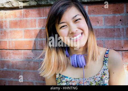 Ritratto di sorridere donna cinese con le cuffie Foto Stock