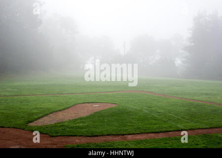 La nebbia oltre il campo da baseball Foto Stock