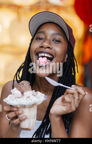 Razza mista donna mostra cuore-forma candy sulla linguetta Foto Stock