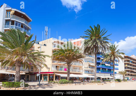 Edifici moderni e palme sulla principale strada costiera di Calafell cittadina nella soleggiata giornata estiva. Regione di Tarragona Catalogna Foto Stock