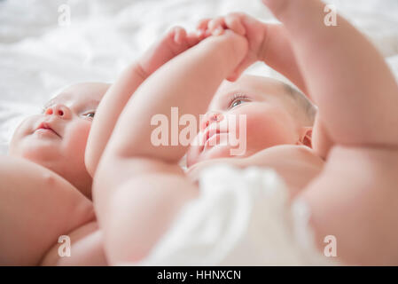 Twin caucasica baby ragazze posa sul letto Foto Stock