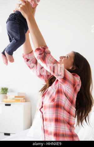 Madre caucasica sollevamento figlia bambino Foto Stock