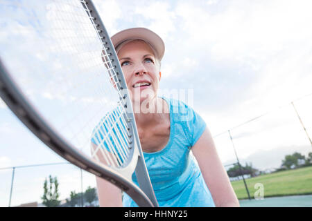 La donna caucasica holding racchetta da tennis Foto Stock