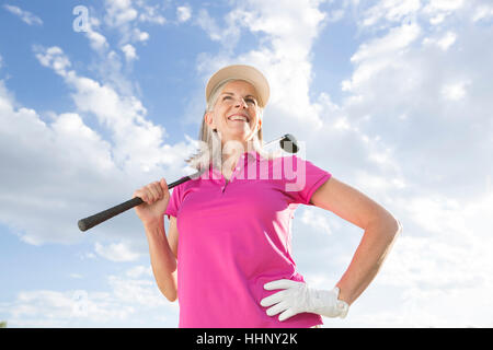 La donna caucasica holding golf club Foto Stock