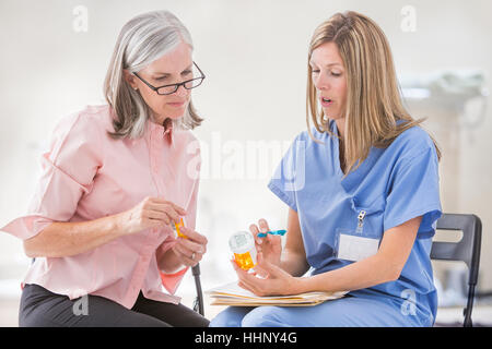 Infermiera caucasica spiegando la prescrizione per il paziente Foto Stock