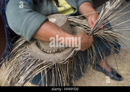 Tessitura a mano un cappello di paglia in San Bartolome Ecuador Foto Stock