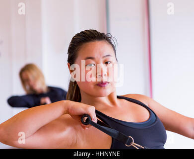 Ritratto di donna asiatica tirando la maniglia in palestra Foto Stock