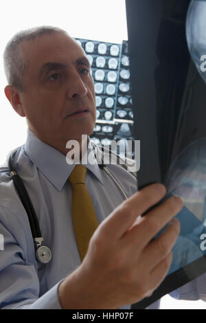 Medico di origine ispanica esaminando x-ray Foto Stock