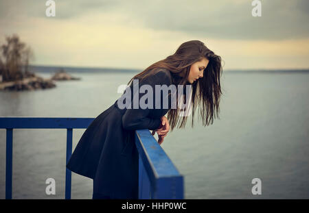 La donna caucasica appoggiata sulla ringhiera a waterfront Foto Stock