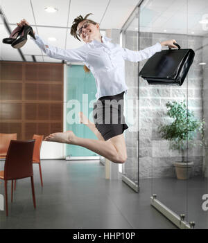 Imprenditrice caucasica jumping in office Foto Stock