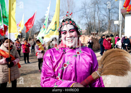 (170120) -- PINGLIANG, Gennaio 20, 2017 (Xinhua) -- un abitante di un villaggio che indossano il costume tradizionale svolge durante un folk art performance nel villaggio di Jiulong, Pingliang City, a nord-ovest della Cina di Provincia di Gansu, 20 gennaio, 2017. Gli abitanti dei villaggi locali terrà un folk art performance per celebrare Xiaonian, che cade venerdì questo anno e segna l inizio del conto alla rovescia per la festa di primavera. (Xinhua/Yang Xin) (wyo) Foto Stock