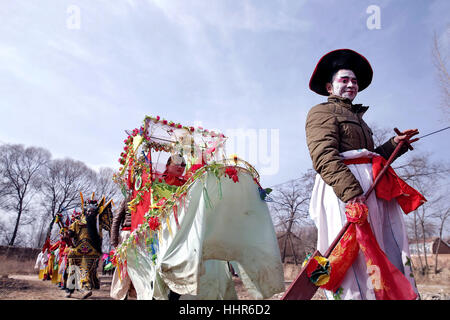 (170120) -- PINGLIANG, Gennaio 20, 2017 (Xinhua) -- gli abitanti di un villaggio indossando costumi parade durante un folk art performance nel villaggio di Jiulong, Pingliang City, a nord-ovest della Cina di Provincia di Gansu, 20 gennaio, 2017. Gli abitanti dei villaggi locali terrà un folk art performance per celebrare Xiaonian, che cade venerdì questo anno e segna l inizio del conto alla rovescia per la festa di primavera. (Xinhua/Yang Xin) (wyo) Foto Stock
