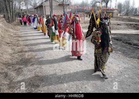 (170120) -- PINGLIANG, Gennaio 20, 2017 (Xinhua) -- gli abitanti di un villaggio indossando costumi parade durante un folk art performance nel villaggio di Jiulong, Pingliang City, a nord-ovest della Cina di Provincia di Gansu, 20 gennaio, 2017. Gli abitanti dei villaggi locali terrà un folk art performance per celebrare Xiaonian, che cade venerdì questo anno e segna l inizio del conto alla rovescia per la festa di primavera. (Xinhua/Yang Xin) (wyo) Foto Stock