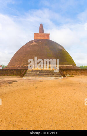 La sporcizia campo leader di primo piano per fasi di Abhayagiri Stupa rovine su un bel cielo azzurro giorno in Campidoglio antico di Anuradhapura Foto Stock