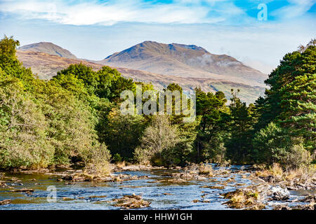 Falls of Dochart precipita attraverso Killin verso Loch Tay con il fiume ponte Dochart centro e Ben Lawers dietro Foto Stock