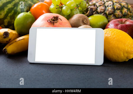 White smartphone con schermo vuoto su fondo fruttato Foto Stock