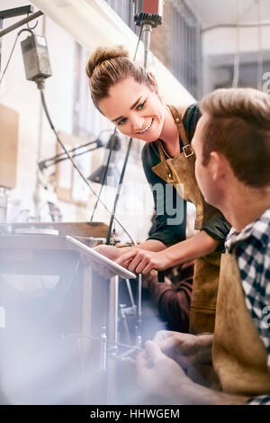 I gioiellieri con tavoletta digitale il lavoro in officina Foto Stock