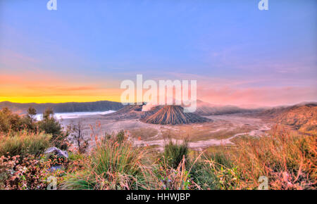 Sunrise, fumatori Monte Bromo, Mt. Batok davanti, a Mt. Kursi sul retro, Mt. Gunung Semeru, Bromo Tengger Semeru National Park, Java Foto Stock