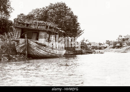 Foto in bianco e nero aggiungere texture in stile vintage del vecchio danneggiato la barca di legno spiaggiata sul lungomare per lo sfondo in Phra Nakhon Si Ayutthaya Foto Stock