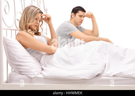 Infelice giovane giacente in letto isolato su sfondo bianco Foto Stock