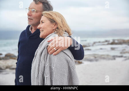 Affettuosa senior giovane costeggiata sulla spiaggia invernale Foto Stock