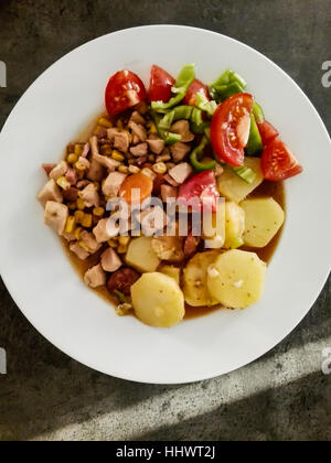 Gustosa carne di pollo con patate, pomodori, il mais dolce e più verdure. In casa Foto Stock