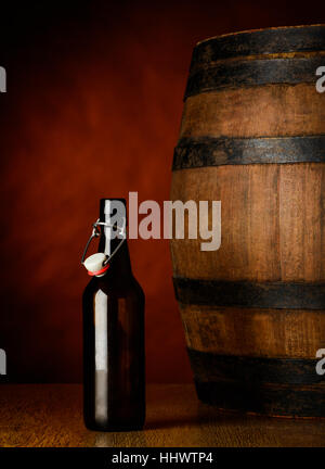 Bottiglia di birra e la canna in una cantina sul tavolo di legno Foto Stock