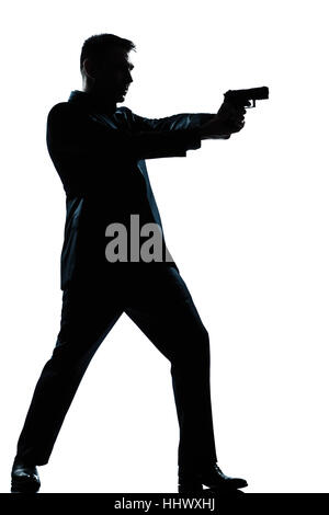 Una spy caucasica poliziotto penale detective uomo che ha di mira la pistola di scatto a piena lunghezza silhouette in studio isolato sfondo bianco Foto Stock