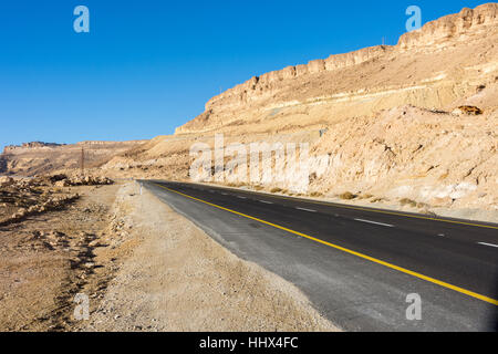 Strade del deserto che conduce al cratere di Ramon (Makhtesh) di Mizpe Ramon nel sud di Israele nel deserto del Negev Foto Stock