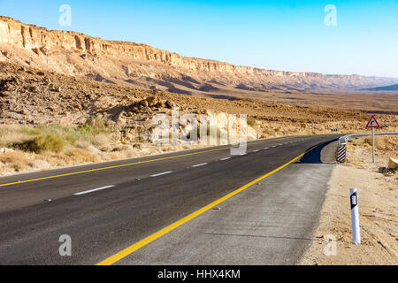 Strade del deserto che conduce al cratere di Ramon (Makhtesh) di Mizpe Ramon nel sud di Israele nel deserto del Negev Foto Stock