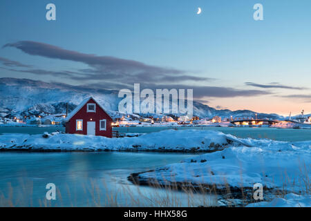 Solitario tipico rosso norvegese casa in legno nella neve al tramonto in inverno Foto Stock