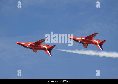 Due frecce rosse BAE Hawk T1A volare a testa in giù contro un cielo blu. Foto Stock