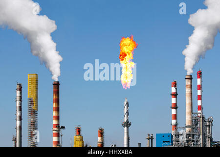 Pile di fumi e gas di combustione in torcia una grande raffineria di petrolio Foto Stock