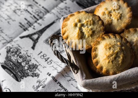Torte di carne macinata in un cesto di vimini su vintage tela di lino, vista dall'alto, copyspace Foto Stock
