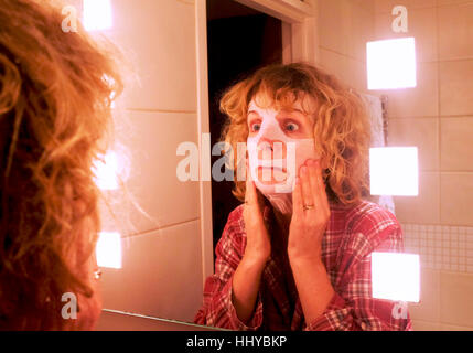 Coppia donna di mezza età che indossa un beauty face mask pack per aiutare l'invecchiamento cutaneo Foto Stock