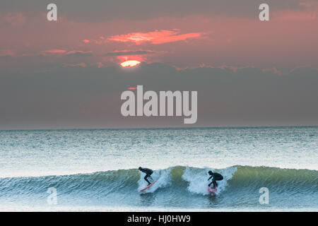 Aberystwyth Wales UK, sabato 21 gennaio 2017 UK meteo: dopo un freddo la notte, con temperature ben al di sotto dello zero, surfisti godersi le onde al tramonto alla fine di una bella giornata di sole caldo in Aberystwyth su Cardigan Bay costa del Galles occidentale foto Keith Morris / Alamy Live News Foto Stock