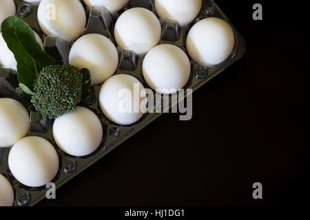 Uova sane con broccoli su sfondo nero Foto Stock