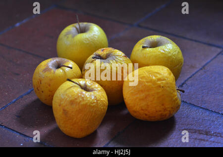 Vecchie mele marcio su piastrelle Foto Stock