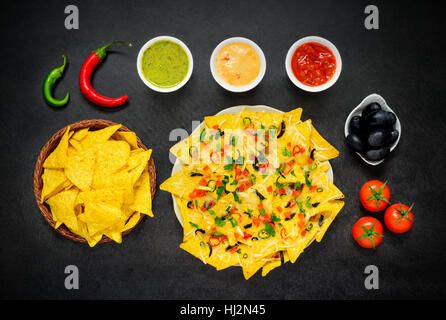 Tortilla Chips Nacho con formaggio, guacamole e dip di pomodoro e peperone in vista superiore Foto Stock