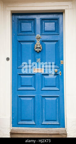 Una porta blu e abbellita da porta in ottone respingente sul 16 College, Durham City in North East England, Regno Unito Foto Stock
