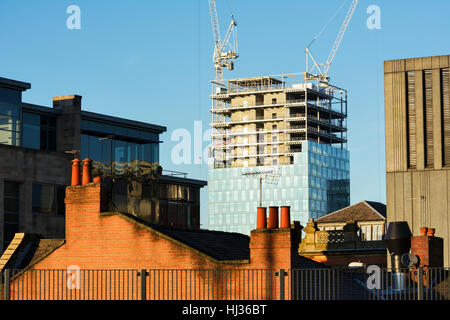 Costruzione di nuovi highrise edificio per uffici nel centro di Manchester giustapposti con tetto di vecchi edifici. Foto Stock