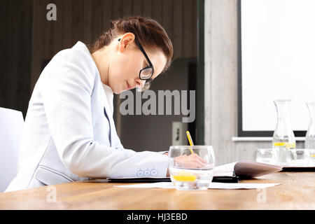 La stampa di documenti. Donne estrarre i documenti di seduta al tavolo della conferenza Foto Stock