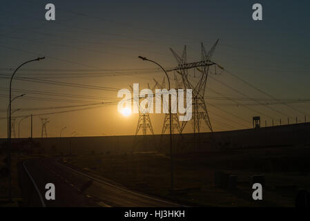 Le linee di alimentazione al tramonto vicino a Itaipu dam si trova sul fiume Paranà che è la linea di confine tra il Brasile e il Paraguay Foto Stock