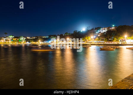 La città in Twilight time con sfocata di barche e di notte le luci sullo sfondo. Una lunga esposizione foto in Buzios, Stato di Rio de Janeiro. Foto Stock